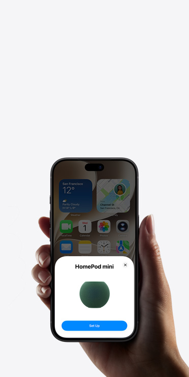 A hand holding an iPhone showing the Home app with a smart home accessory setup prompt