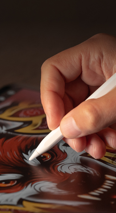 Une main tient un Apple Pencil, et dessine sur iPad.