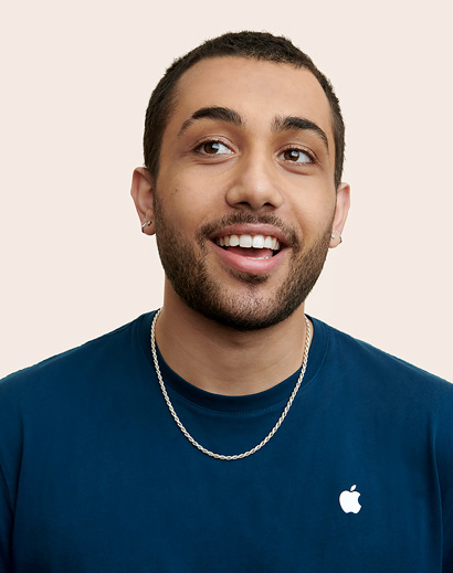Apple Retail employee smiling and looking away from the camera.