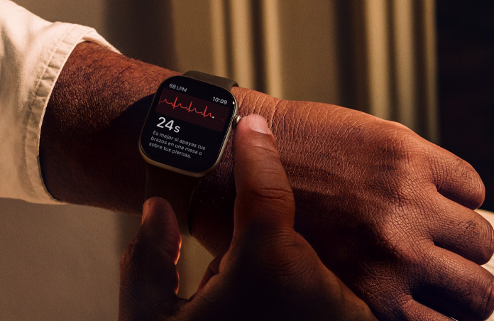 Una persona mantiene presionada la Digital Crown de un Apple Watch Series 11 para medir su salud cardiaca en la app ECG