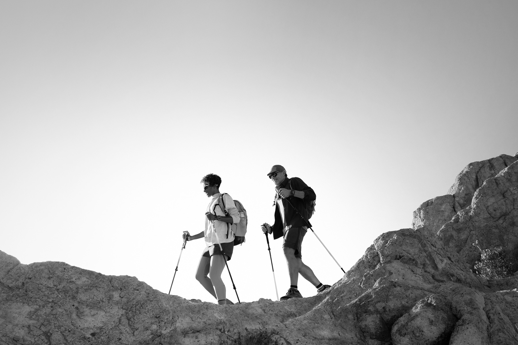 Two people wearing Apple Watch Ultra 3 hike a mountain trail