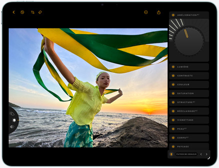 iPad Air, face avant, retouche d’une photo d’une personne tenant un tissu vert et jaune sur une plage au coucher du soleil, avec des outils d’édition visibles sur le côté droit