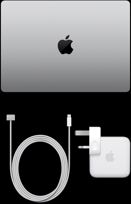 MacBook Pro, silver color, top, closed, next to charging cable and adapter