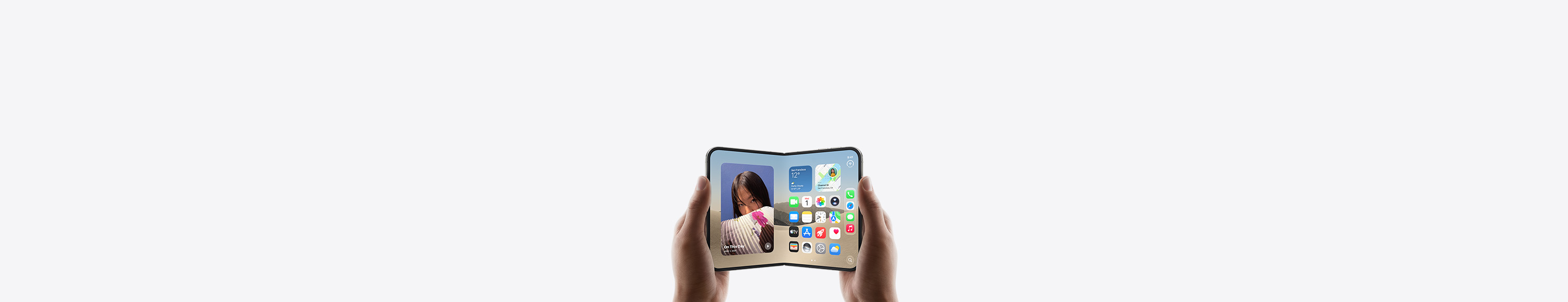 兩隻手拿著橫向的 iPhone Duo，裝置打開，內螢幕展示主畫面。