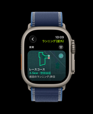 Apple Watch Ultra 3、カラーはナチュラル、チタニウムケース。レースコース、屋外ランニングのワークアウトが表示されている。ブルー/ブライトブルーのトレイルループバンド