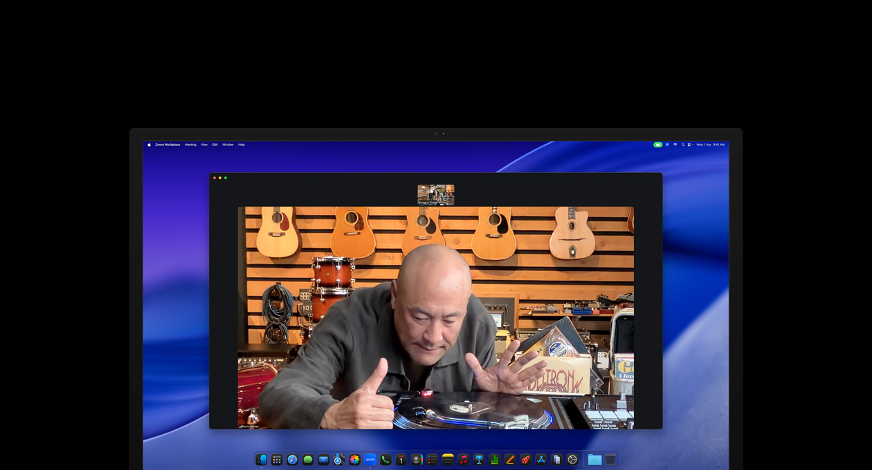 While on a video call, a person at a music store looks closely at a turntable, he remains centered in the frame thanks to the Center Stage camera