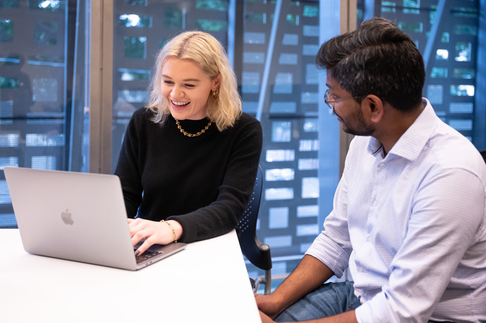 A UTS lecturer teaching coding skills to a student on her MacBook Pro.
