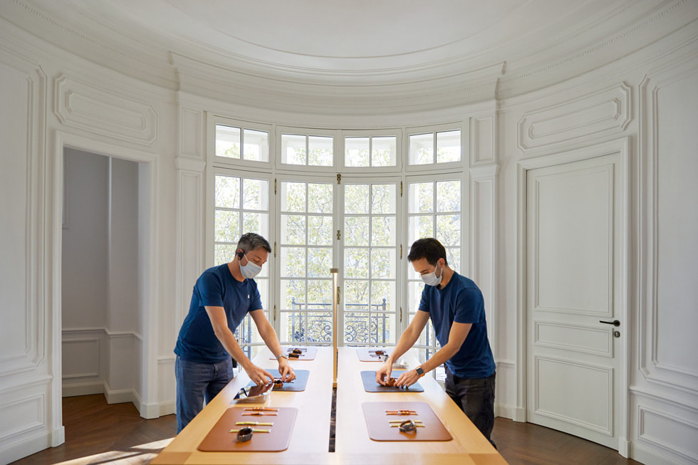 Deux employés d’Apple mettent en place des produits dans un Apple Store en France.