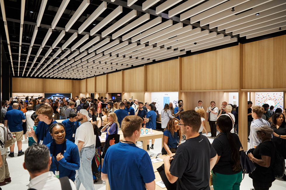 A crowd of team members and customers inside Apple Battersea in London.