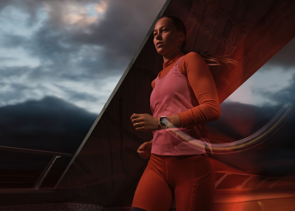 A person wearing Apple Watch Series 9 is shown running outdoors on a cloudy day, with a motion blur effect.