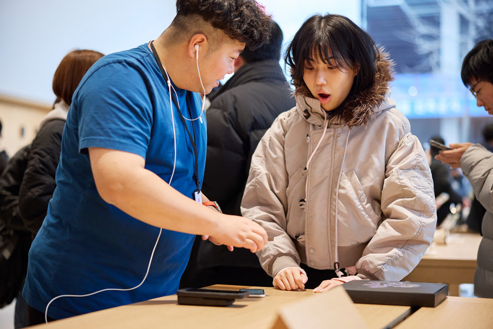 An Apple team member assists a customer with a purchase.