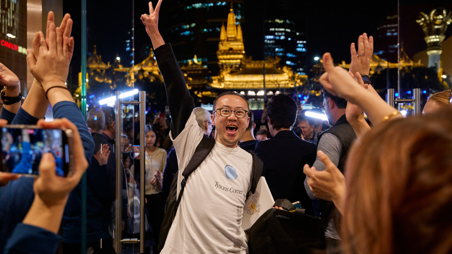 Team members welcome the first customers through the doors at Apple Jing’an, Apple’s eighth store in Shanghai.