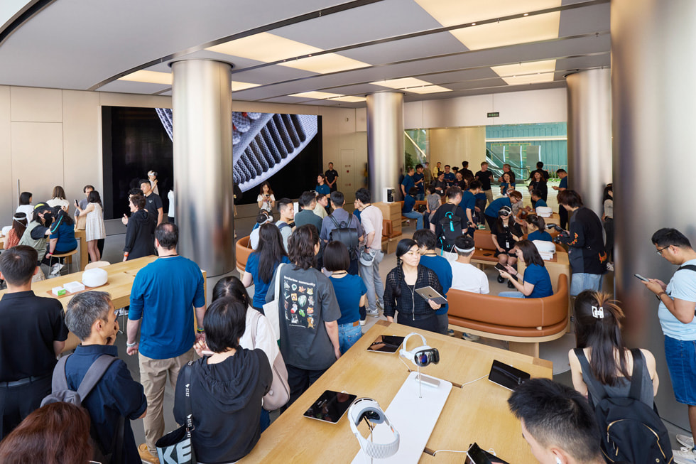 A zoomed-out shot inside Apple Wangfujing shows customers exploring the store, with the Demo Zone toward the rear.