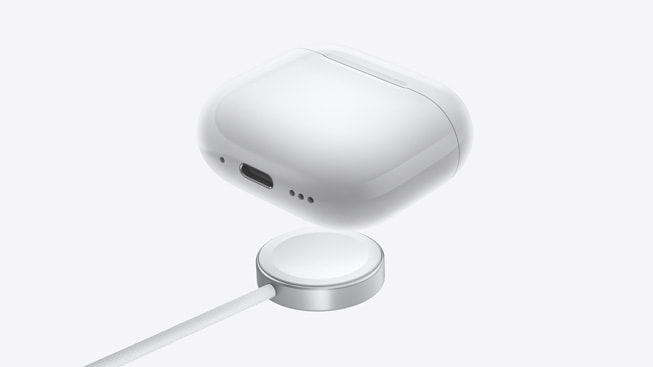 AirPods 4, Apple Watch şarj aygıtıyla birlikte gösteriliyor.
