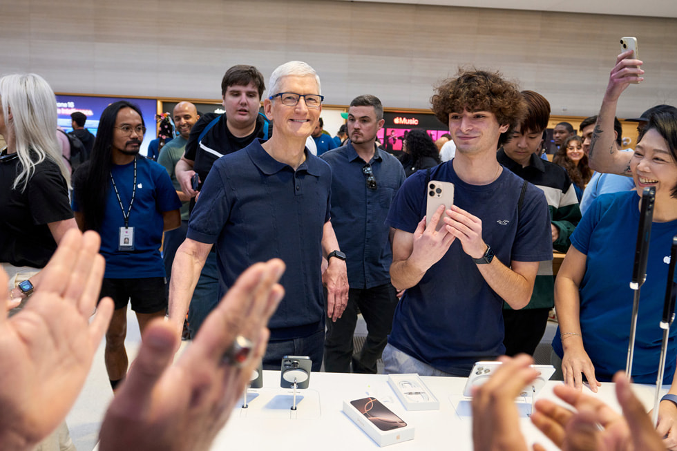 Tim Cook sourit et prend la pose avec des clients et des membres d’équipe à Apple Fifth Avenue, à New York.