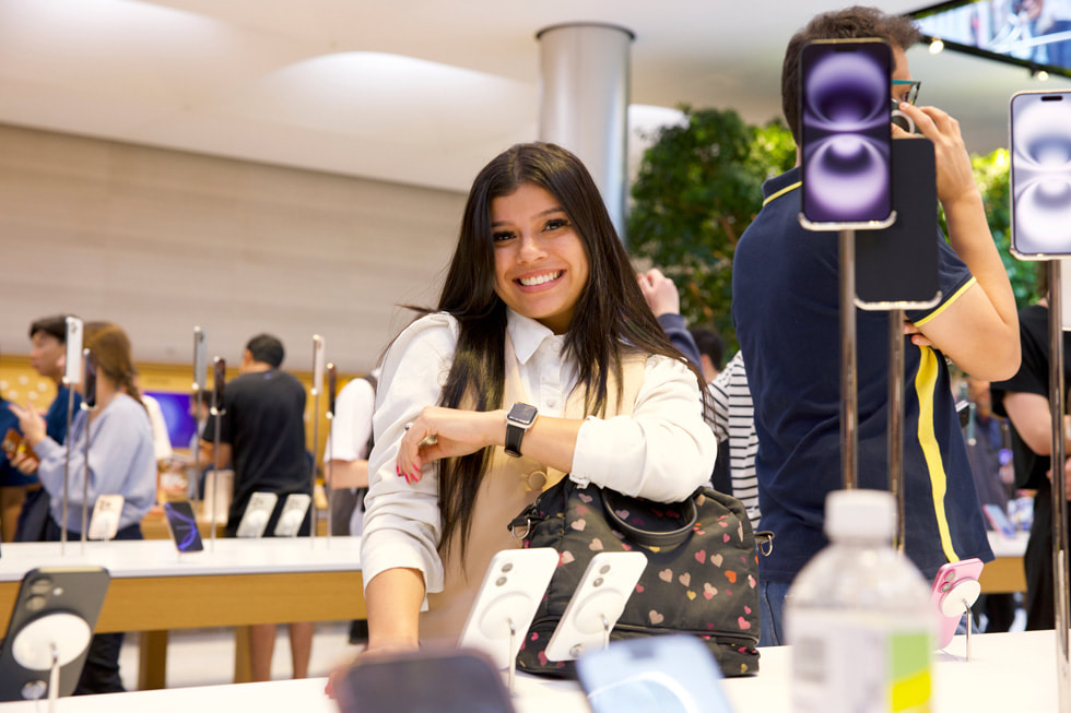 Une cliente souriante montre la nouvelle Apple Watch Series 10 à Apple Fifth Avenue, à New York.
