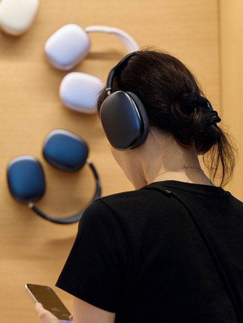 Une cliente teste la qualité audio des AirPods Max.