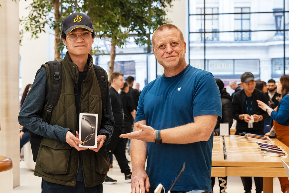 Un client pose avec son nouvel iPhone 16 Pro à côté d’un employé à Apple Regent Street, à Londres.