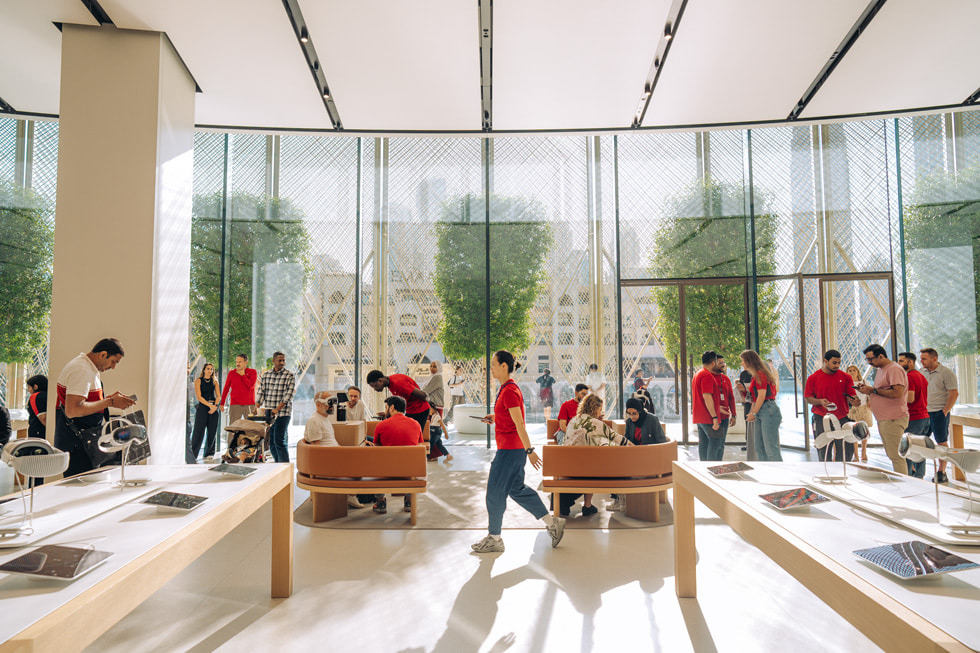 لقطة واسعة داخلية لمتجر Apple Store في الإمارات العربية المتحدة، حيث يعّج بالعملاء وأعضاء فريق Apple.