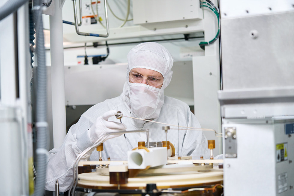 A worker in protective clothing examines machinery at Texas Instruments’ semiconductor wafer fabrication plant in Lehi, Utah.
