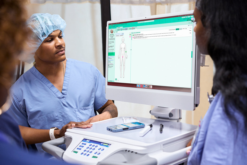 A care team using an iMac situated on a cart in a patient room at Emory Hillandale Hospital.