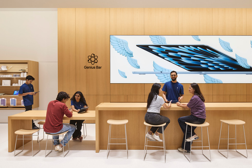 Team members assist customers at the Genius Bar inside Apple Koregaon Park.