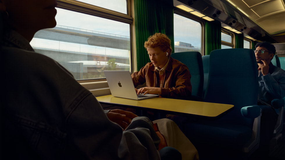 An image of a user wearing AirPods Pro 3 while commuting on a train.