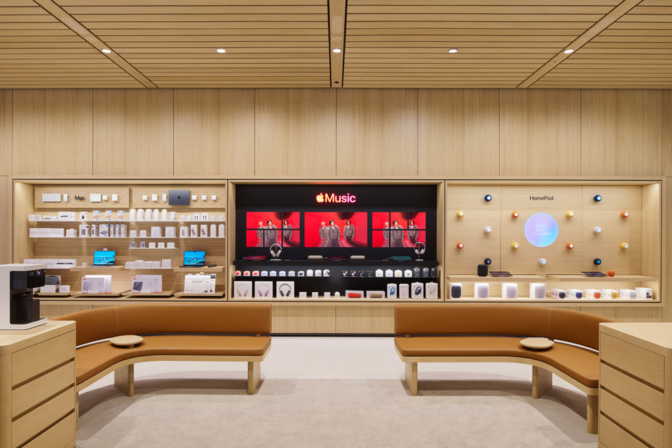 An interior view of Apple Ginza features couches and screens showing content from Number_i.