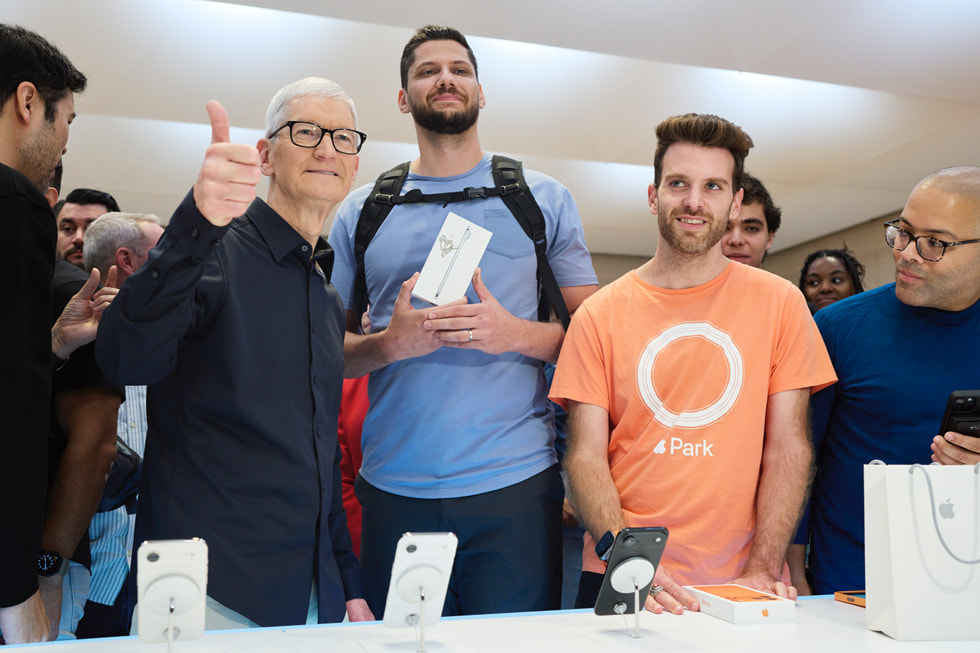 Tim Cook poses for a photo with an iPhone Air customer.