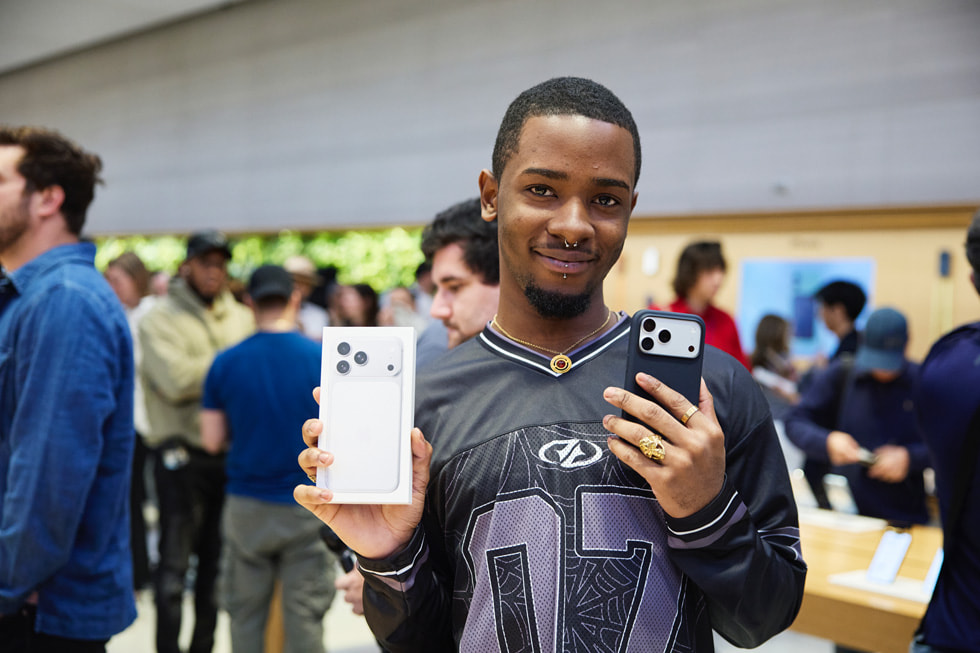 A customer shows off their silver iPhone 17 Pro.