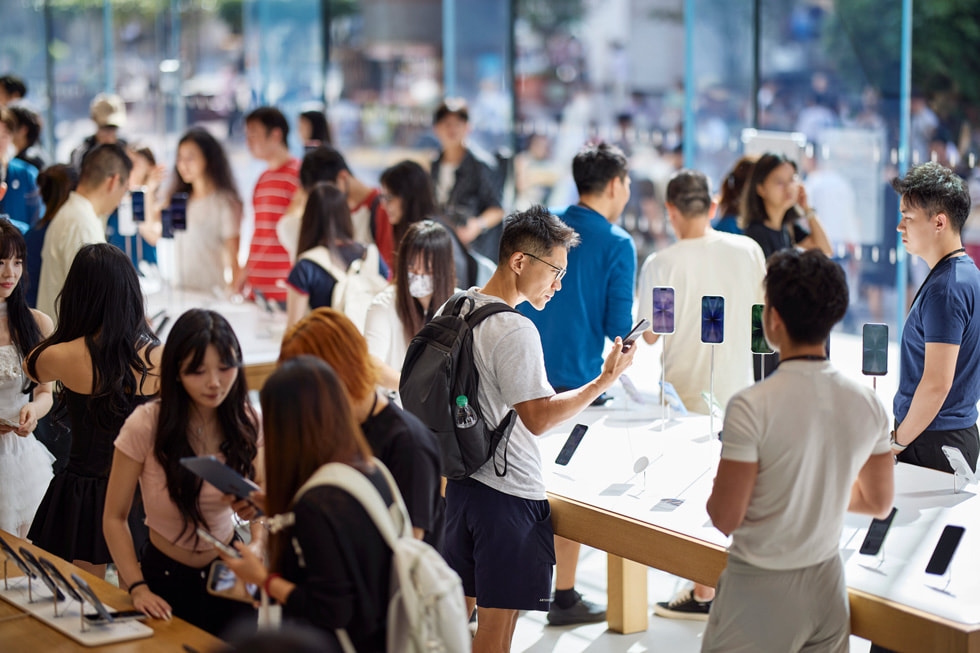 Customers explore the latest iPhone lineup at Apple Nanjing East in Shanghai.