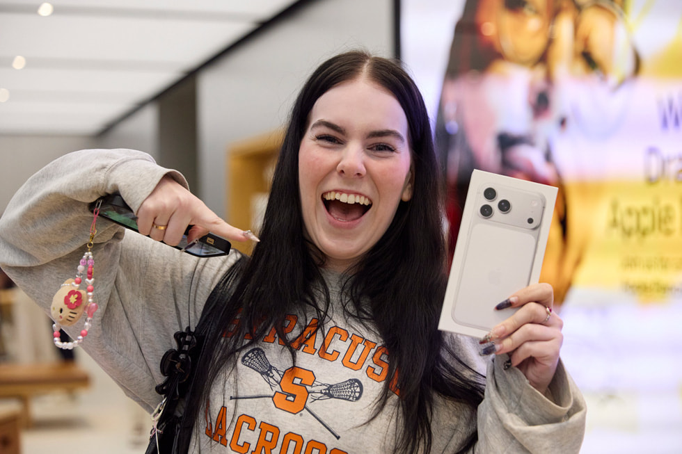 An excited customer poses with their new iPhone 17 Pro purchase.