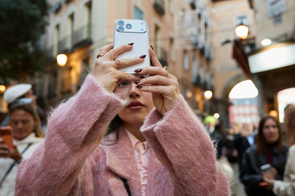 Participante sujetando un iPhone 17 Pro en la calle.