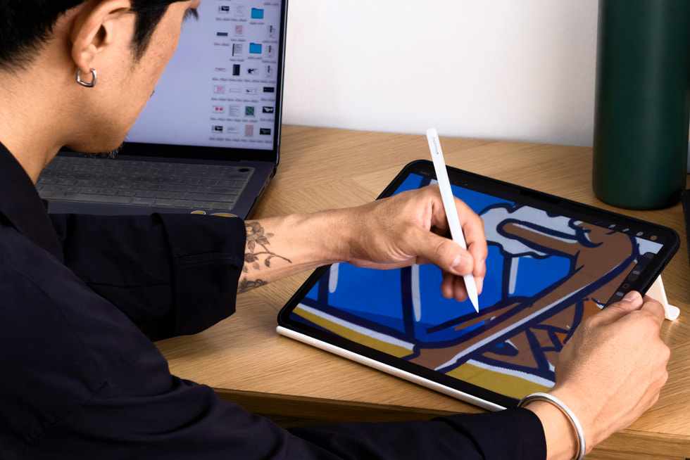 Artist Kentaro Yoshida is shown working on iPad Pro, which features an illustration on the screen.