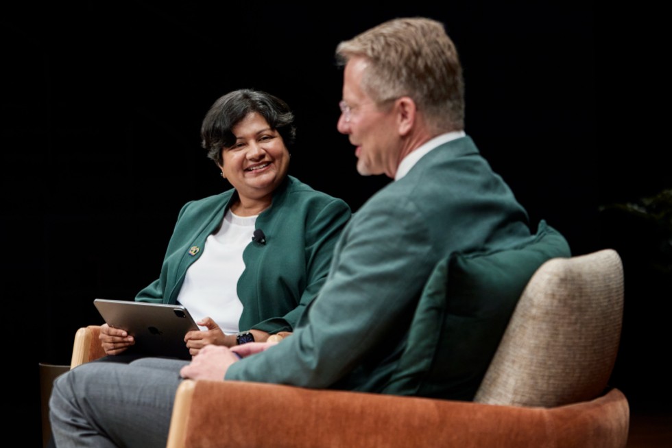 Priya Balasubramaniam and Kevin M. Guskiewicz are pictured speaking to each other while sitting down.