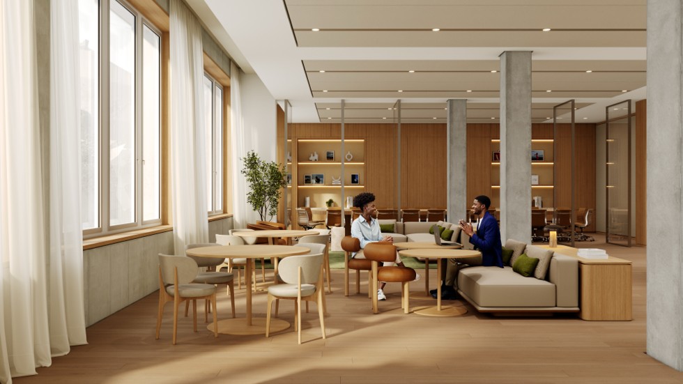 Mehrere Personen haben sich in einem modernen, hell beleuchteten Pausenbereich mit Holzmöbeln versammelt, darunter Tische, Stühle und ein bequemes Sofa.
