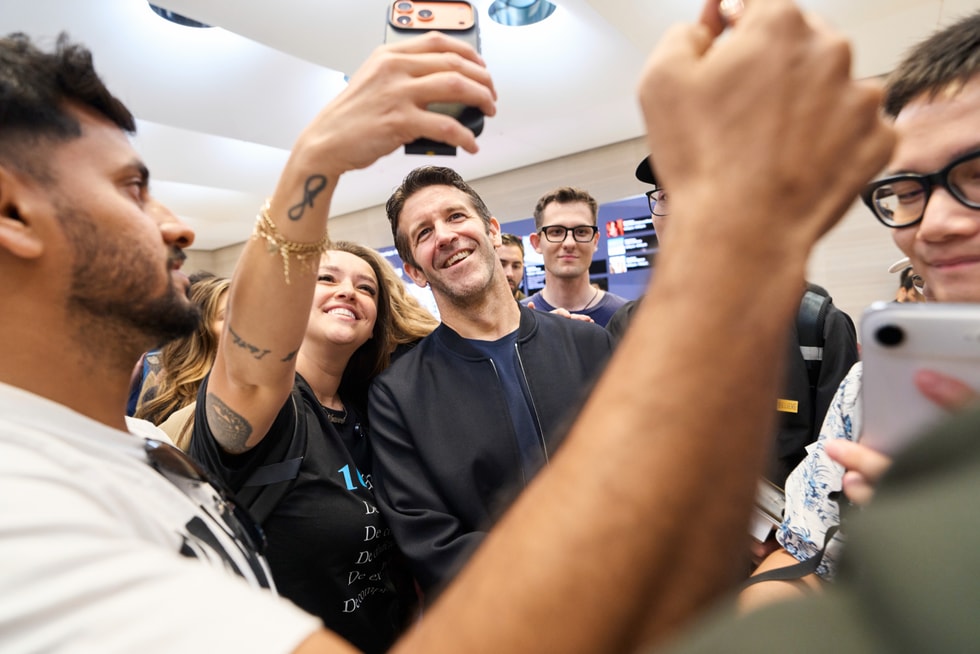 John Ternus smiles for a photograph with a customer at Apple Fifth Avenue.