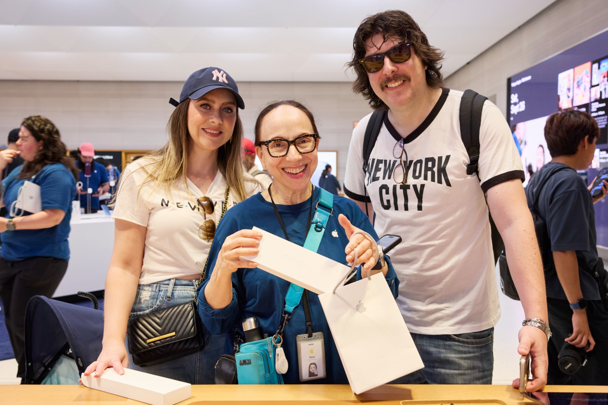 An Apple team member helps customers with their Apple Watch purchases at Apple Fifth Avenue.