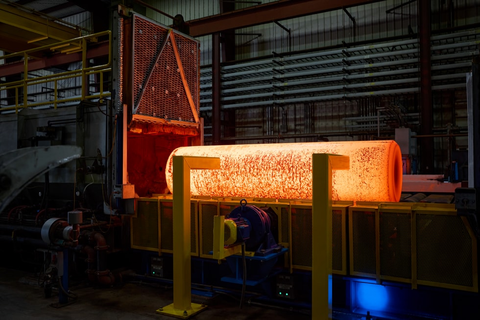 A glowing yellow tube of hot titanium moves through a Perryman Company foundry.
