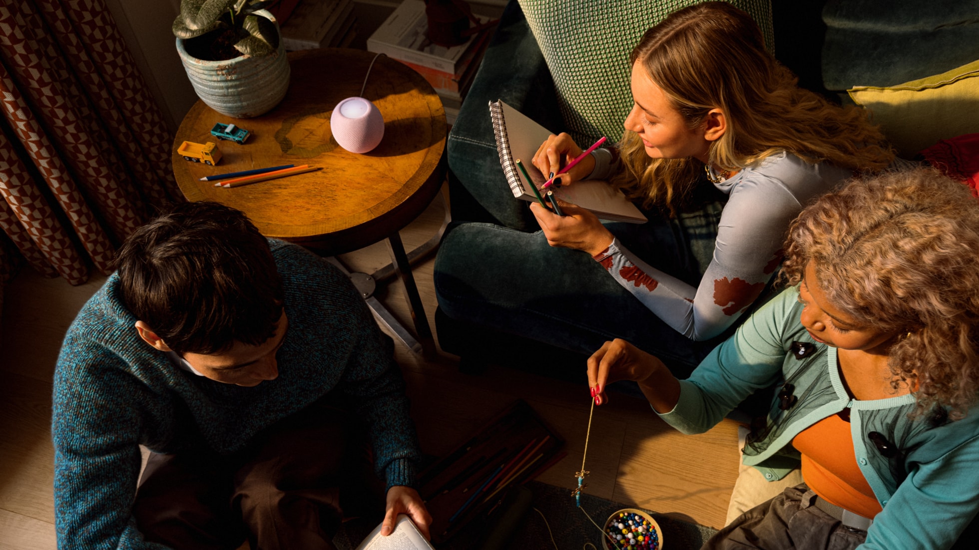 A group relaxes with HomePod mini 2 in the background.