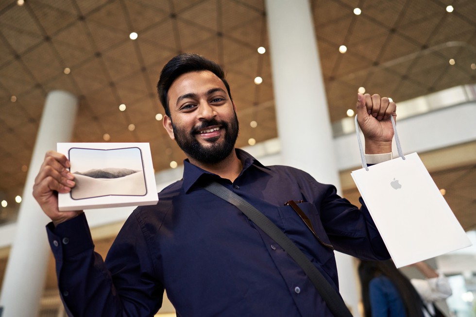 At Apple BKC, a customer holds up a new iPhone Duo purchase.
