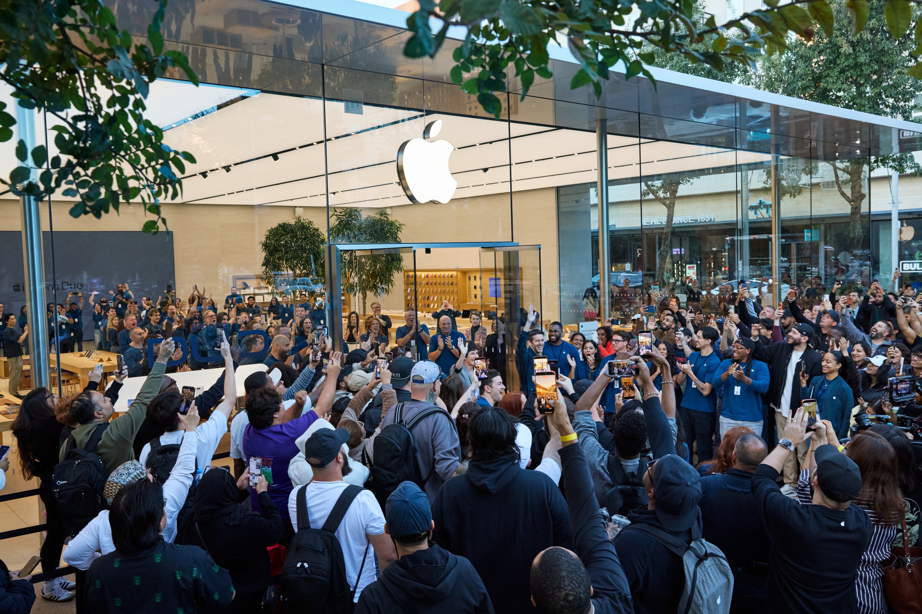 A crowd of customers in front of Apple Domain NORTHSIDE, with Deirdre O’Brien and John Ternus in the centre.