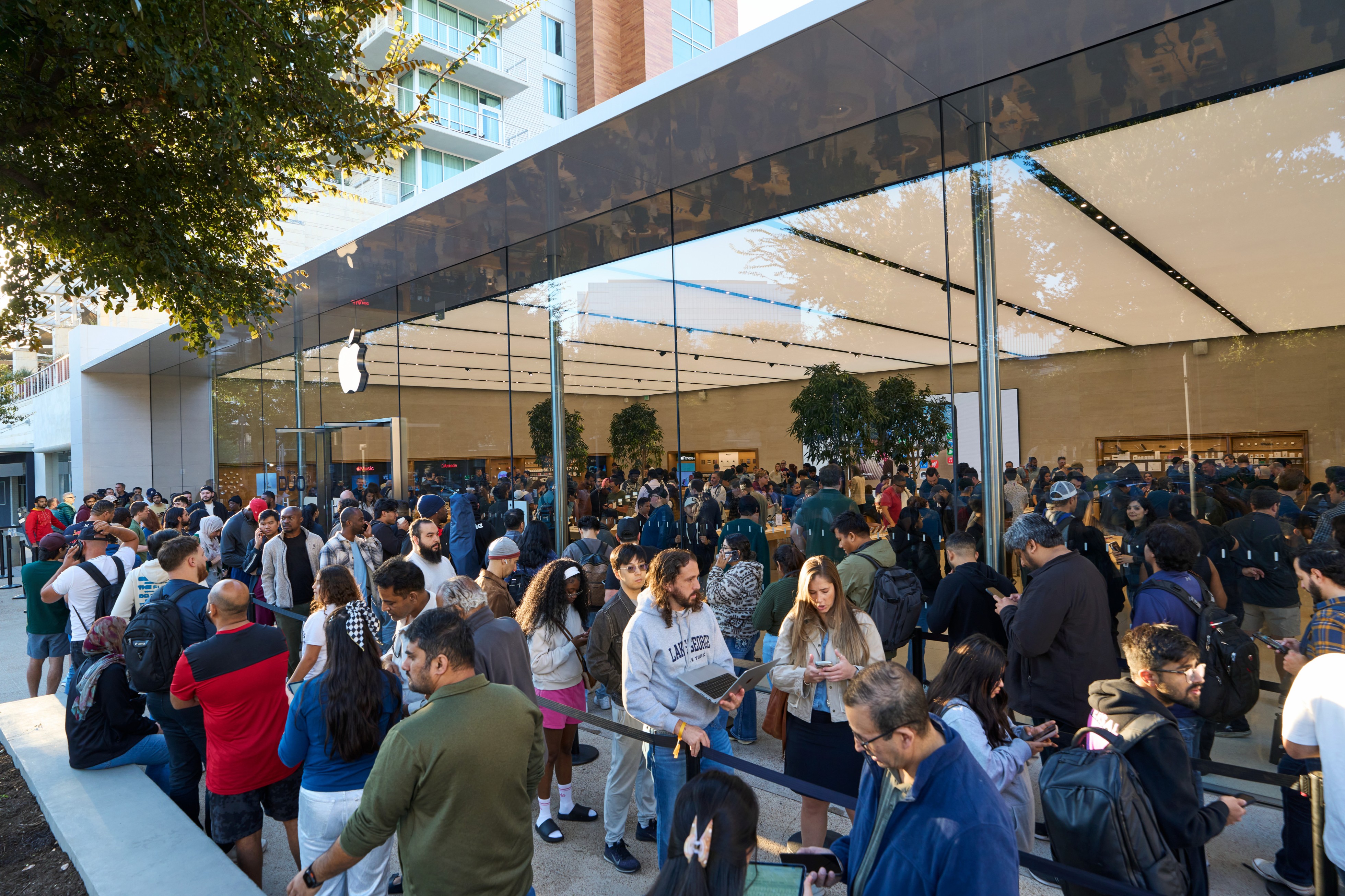 The bustling exterior of Apple Domain NORTHSIDE, with customers lined up to enter the store.