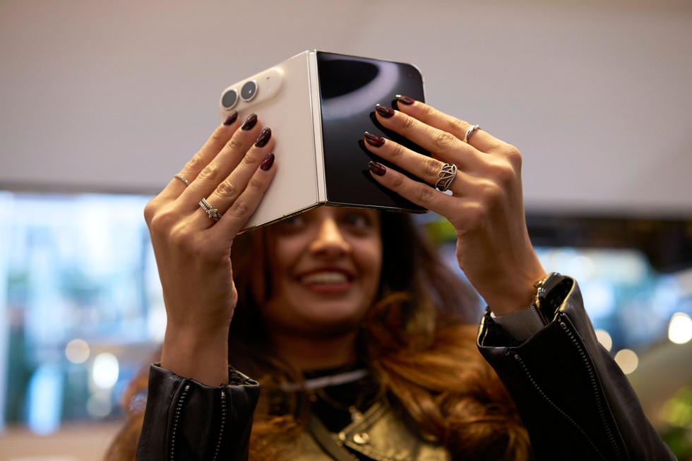 A close-up of a customer looking at a partially folded iPhone Duo at Apple Fifth Avenue.