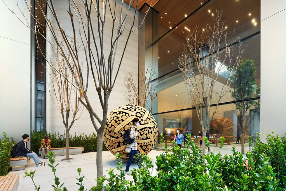 Customers explore a pocket garden outside of Apple Myeongdong.
