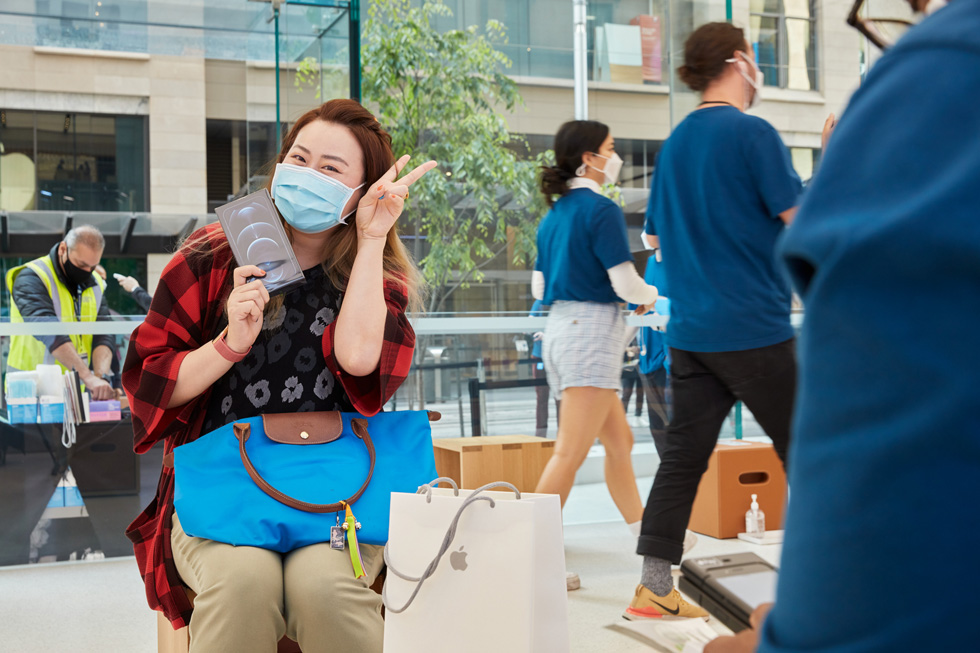 A customer at Apple Sydney shows off her new iPhone 12 Pro Max purchase. 