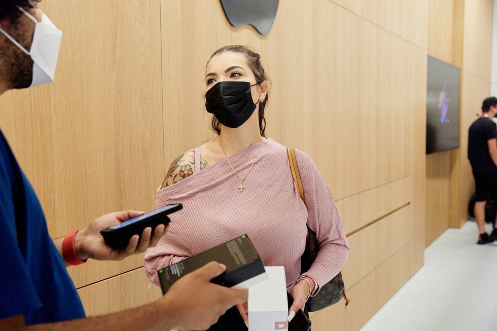 A team member at Apple Bay Plaza helps a customer with an iPhone 13 Pro purchase.