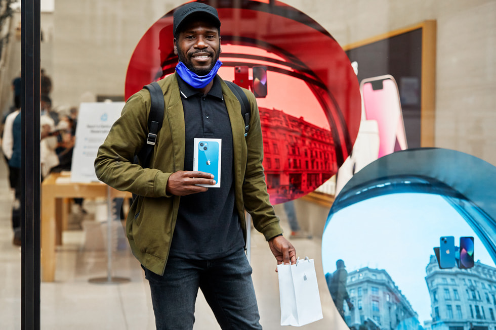 An Apple Regent Street customer showing off his new iPhone 13 purchase. 