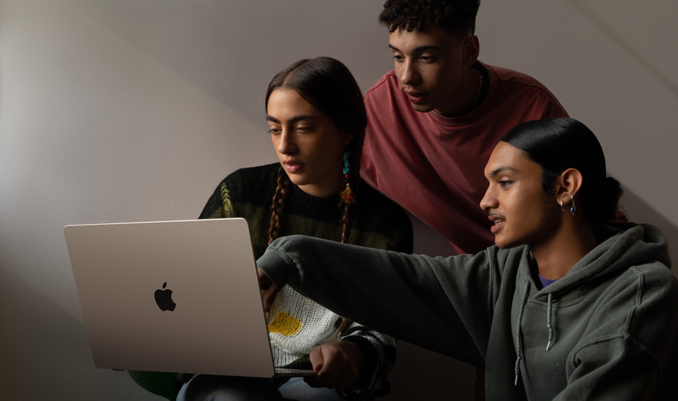 Three people looking at the 15-inch MacBook Air.