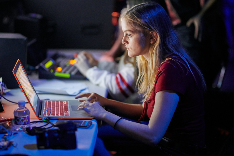 バックステージでコンピュータを駆使する生徒プロデューサー。